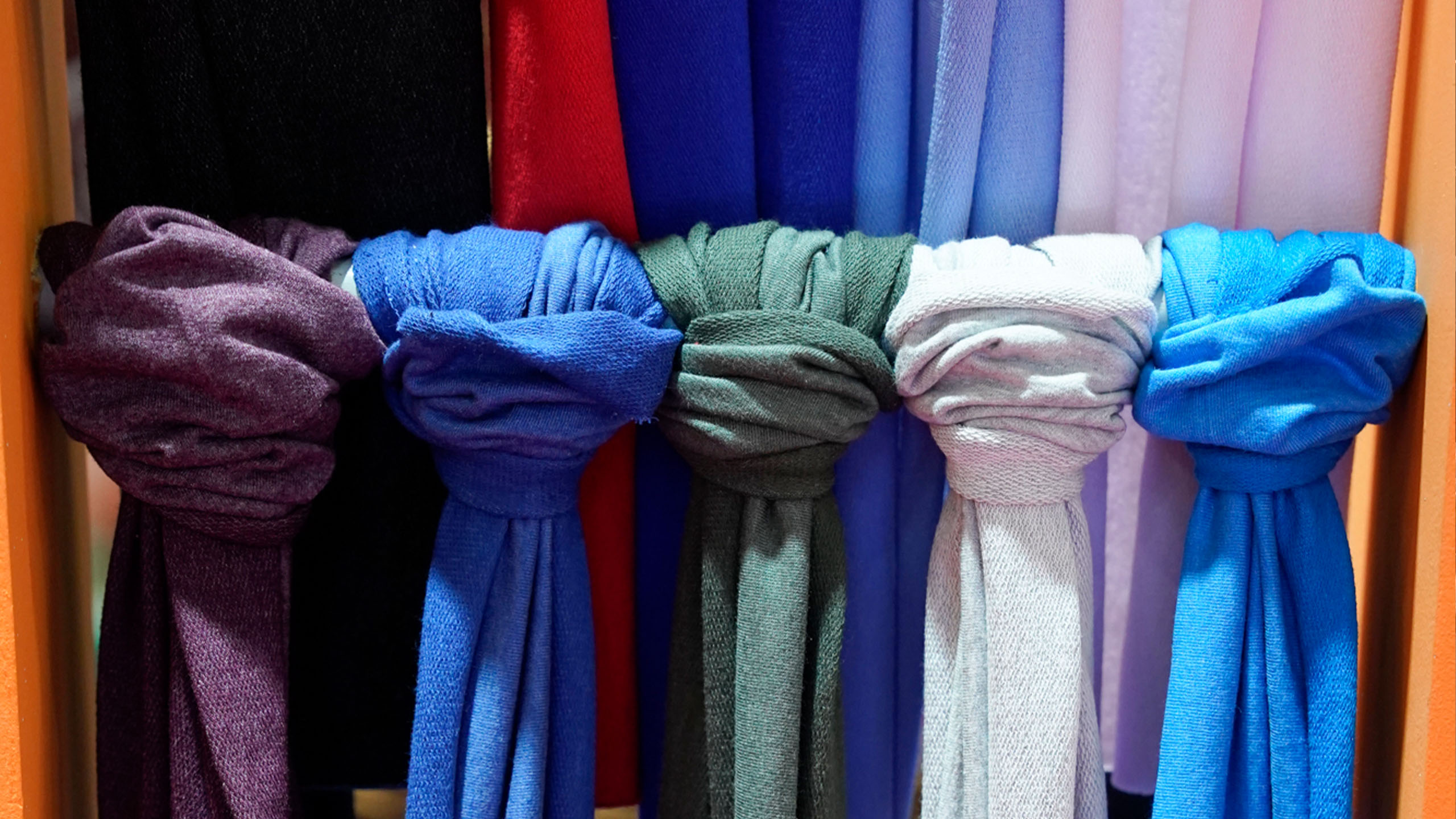 Foto de telas de varios colores atadas en un barral ubicado en un stand de Emitex